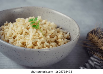 Bowl Of Cooked Whole Grain Brown Rice On Wooden Background Overhead View