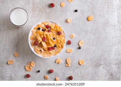 bowl of corn granola with milk, fresh raspberries, blueberries . milk in a jug and a glass  on white wooden board for healthy breakfast, top view - Powered by Shutterstock