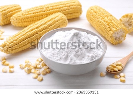 Bowl of corn starch, ripe cobs and kernels on white wooden table