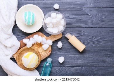 Bowl With Cotton Balls, Cosmetics And Bath Bombs On Grey Wooden Background