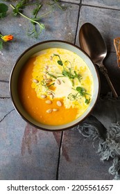 Bowl Of Creamy Carrot Soup With Cream On The Table