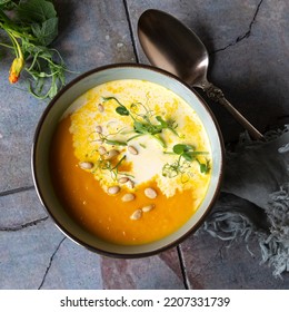 Bowl Of Creamy Carrot Soup With Cream On The Table