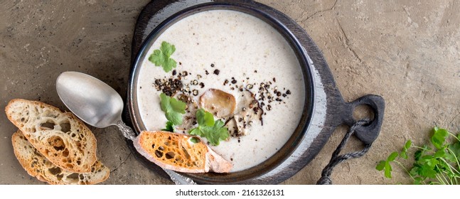 A Bowl Of Creamy Porcini Mushroom Soup On A Light Table