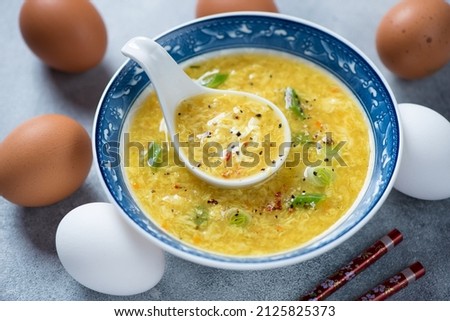Bowl of danhuatang or chinese soup of wispy beaten eggs in chicken broth, middle closeup, horizontal shot