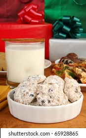 A Bowl Of Danish Wedding Cookies With Eggnog, Fruitcake And Christmas Gifts