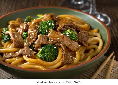 A Bowl Of Delicious Beef Teriyaki With Brocolli, Udon Noodles And Sesame Seed Garnish.