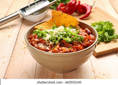 Bowl with delicious chili turkey on wooden table