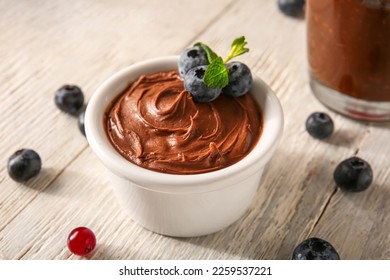 Bowl of delicious chocolate pudding, blueberry and mint on white table - Powered by Shutterstock