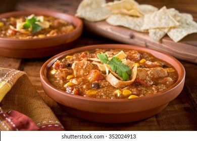 A Bowl Of Delicious Home Made Chicken Tortilla Soup With Chicken, Corn, Black Bean, Tomato, Hominy, And Tortilla.