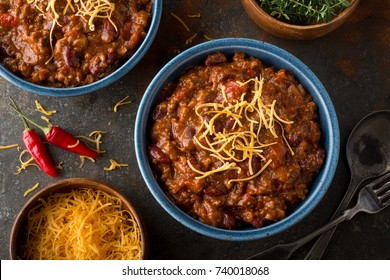 A Bowl Of Delicious Home Made Chili With Ground Beef, Kidney Beans, Red Pepper, Tomato And Shredded Cheddar Cheese.