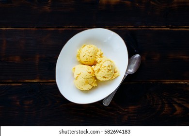 Bowl Of Delicious Homemade Mango Ice Cream Over Wooden Textured Background. Flat Lay With Copy Space. Top View