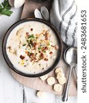 A bowl of delicious homemade New England clam chowder with parsley garnish and salted crackers