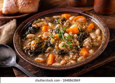 A Bowl Of Delicious Italian Sausage, Kale And White Bean Cannellini Soup With Thyme Garnish.