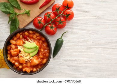 Bowl with delicious turkey chili on wooden background