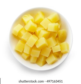 Bowl of diced boiled potatoes isolated on white background, top view