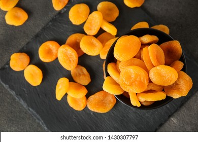 Bowl with dried apricots on slate plate