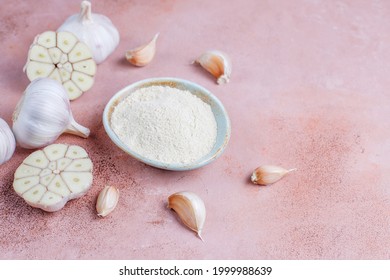 Bowl With Dried Garlic Powder And Garlic Bulbs.