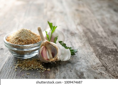 Bowl With Dried Garlic Powder On Wooden Background