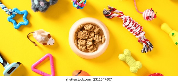 Bowl of dry food for pet, cat and dog toys on yellow background. Flat lay, top view. - Shutterstock ID 2311547607