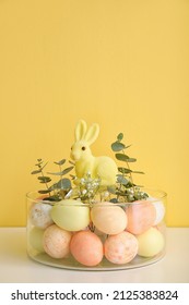 Bowl and Easter eggs  rabbit   floral decor table near color wall