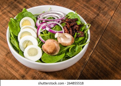 Bowl Of Egg And Spinach Salad With Mushrooms And Onions