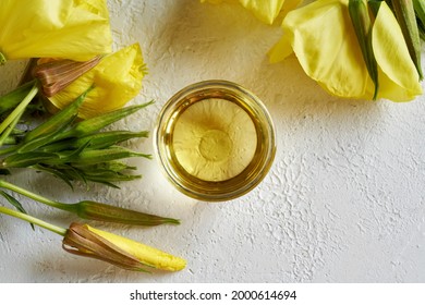 A Bowl Of Evening Primrose Oil With Fresh Plant On White Background, Top View