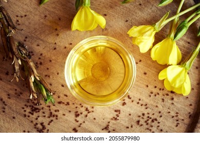 A Bowl Of Evening Primrose Oil With Fresh Blooming Plant And Seeds, Top View