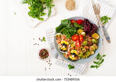 Bowl with Farfalle pasta, Brussels sprouts with bacon and fresh vegetable salad. Flat lay. Top view - Powered by Shutterstock