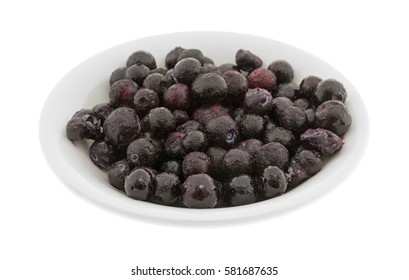 A Bowl Filled With Frozen Wild Blueberries Isolated On A White Background.