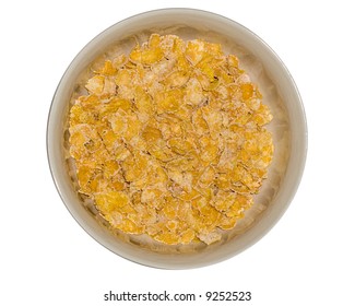 A Bowl Of Flaked Corn Cereal. Overhead, Isolated Over White.