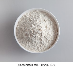 bowl of flour on grey kitchen table background, top view, selective focus