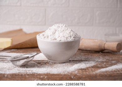 bowl with flour, sieve and rolling pin for dough on wooden table side view

 - Powered by Shutterstock