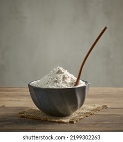 Bowl Of Flour And Spoon On Wooden Kitchen Table