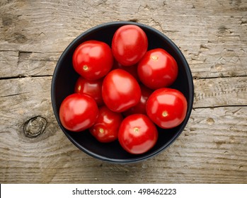 Bowl Of Fresh Cherry Tomatoes On Wooden Background, Top View