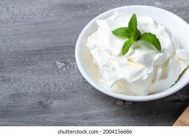 Bowl with fresh cottage cheese on a wooden table