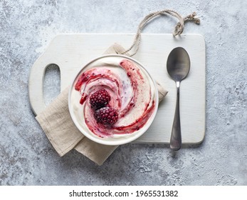 Bowl Of Fresh Greek Yogurt With Jam And Frozen Berries On Kitchen Table, Top View