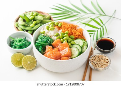 Poké bowl with fresh salmon, rice, chukka salad, edamame beans, carrots and cucumber. Bowl of healthy food on white background  - Shutterstock ID 1912808707