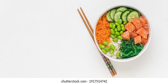 Poké Bowl With Fresh Salmon, Rice, Chukka Salad, Edamame Beans, Carrots And Cucumber. Bowl Of Healthy Food On White Background 