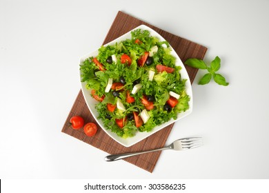 Bowl Of Fresh Vegetable Salad On Brown Place Mat