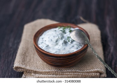 Bowl Of Fresh Yogurt Dip With Dill And Garlic On Wooden Background. Selective Focus