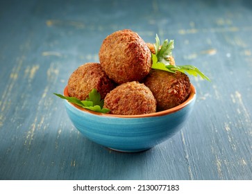 bowl of fried falafel balls on blue wood table - Powered by Shutterstock