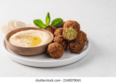 Bowl of fried falafel and hummus dip. Middle Eastern cuisine snack. Close-up view, side view