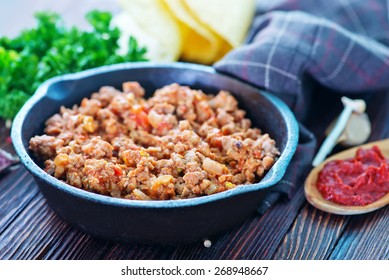 a bowl of fried ground meat with tomatoes ready for tacos