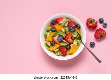 Bowl with fruit salad on pink background. Strawberry, blueberry, kiwi, orange, apple slices. Healthy quick snack concept - Shutterstock ID 2231564841