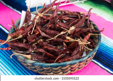 Bowl full of dried red chili peppers over a traditional mexican napkin background. Isolated view from above closeup. Traditional mexican spice used for cooking and food preparation - Powered by Shutterstock