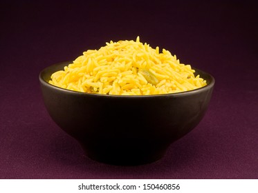 Bowl full of pilau rice a special gourmet indian side dish flavoured with spices from india including cumin, cardamom and bay leaves