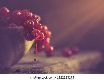 Bowl full of red berries on a rustic wooden table