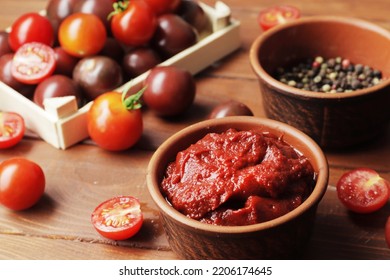 Bowl Full Of Tomato Sauce, Wooden Spoon Full Of Tomato Sauce, Spices, Seasonings, Sliced Ripe Cherry Tomato Slices,  Procurement Of Ingredients For Recipes.