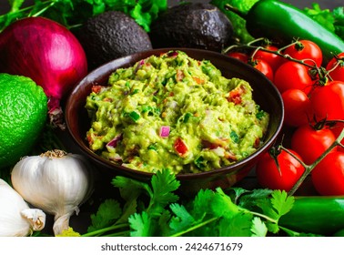 Bowl of Guacamole Surrounded by Fresh Ingredients: Guacamole with Hass avocados, jalapeno peppers, cherry tomatoes, and other ingredients - Powered by Shutterstock