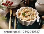 A bowl of handmade traditional  Christmas dumplings with sauerkraut and mushroom filling on festive table